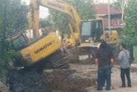 Operator ekskavator melakukan pekerjaan proyek penggalian drenase alami kecelakaan tunggal