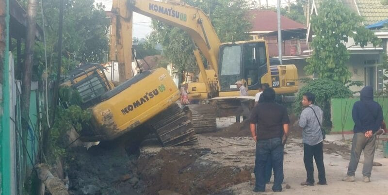 Operator ekskavator melakukan pekerjaan proyek penggalian drenase alami kecelakaan tunggal