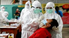 Petugas kesehatan mengambil sampel usap COVID-19 dari seorang penumpang kereta api di Stasiun Bogor dekat Jakarta. Foto: (The Jakarta Post)